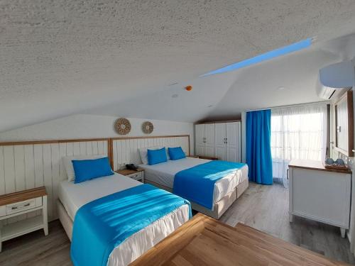 切什梅Bahar Butik Otel的蓝色和白色的客房内的两张床
