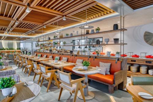 a restaurant with tables and chairs and a bar at The First Collection Business Bay in Dubai