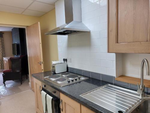 a kitchen with a sink and a stove top oven at Apartment above Sweetharts bakery and coffeeshop in Blackhill, Durham in Shotley Bridge