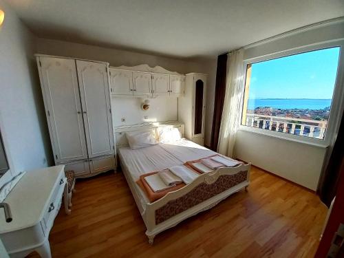 a bedroom with a bed and a large window at Guest House Rona - Free Parking and Sea View in Sveti Vlas