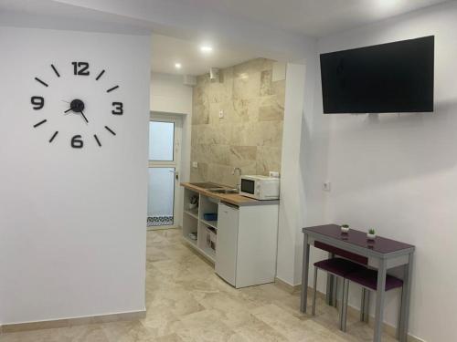uma cozinha com um relógio na parede e uma mesa em Estudio Conil Playa em Conil de la Frontera