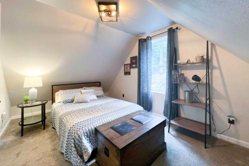 a bedroom with a bed with a table and a window at On the Rocks - A Modern Home with Decks and Views in Cloudcroft