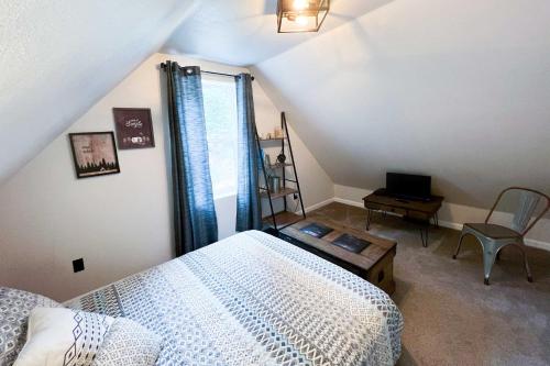 a bedroom with a bed and a desk and a window at On the Rocks - A Modern Home with Decks and Views in Cloudcroft