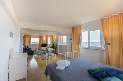 a bedroom with a bed and a living room at Casa Eden in Costinesti