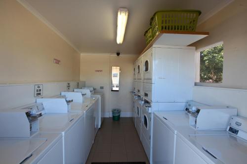 Habitación grande con encimeras y electrodomésticos blancos. en Leichhardt Accommodation, en Mount Isa