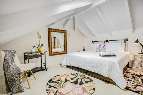 een slaapkamer met een bed, een spiegel en een stoel bij Paniolo #202 A & B in Princeville