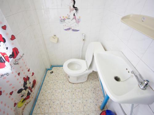 a bathroom with a toilet and a sink at Chaiwat Resort in Laem Sing
