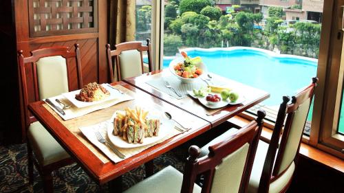 a table with food on it with a view of a pool at The Howard Plaza Hotel Taipei in Taipei