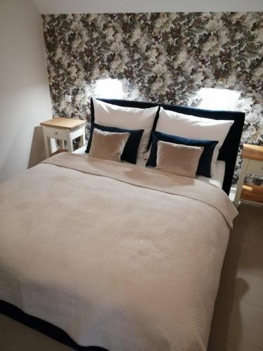 ein Schlafzimmer mit einem großen weißen Bett mit Blumentapete in der Unterkunft Kaszmir in Karpacz