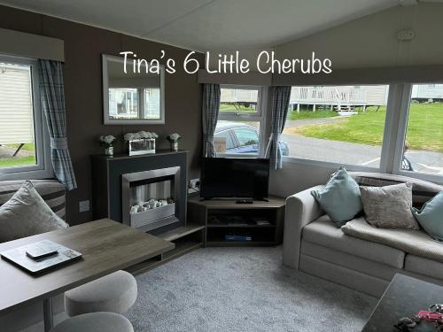 un soggiorno con divano e TV di 6 Little Cherubs Holiday Home a Cowes