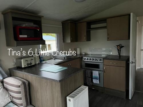 a kitchen with a counter and a stove top oven at 6 Little Cherubs Holiday Home in Cowes