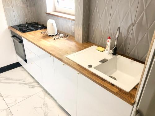 a kitchen counter with a sink and a stove at Orłowska by the Sea Apartment in Gdańsk