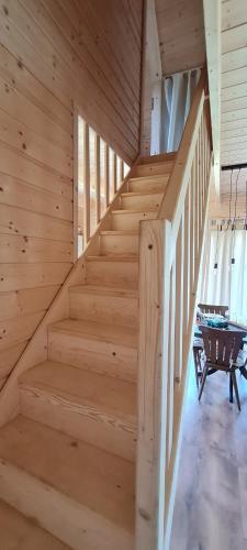 a staircase in a wooden cabin with a table at Sunset House in Sulęczyno