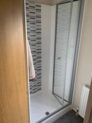 y baño con ducha y puerta de cristal. en Ocean Edge Holiday Park Family holiday home with spectacular sea views, en Heysham