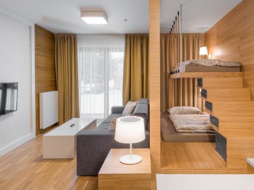 sala de estar con sofá y cama en Suites and Apartments Medvědín, en Špindlerův Mlýn