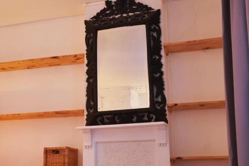 a mirror sitting on top of a fireplace at OPARADI "L'atypique" MAISON HISTORIQUE à Lille, un séjour atypique dans un cadre d'antan in Lille
