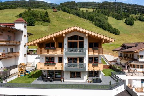 an image of a building with a hill in the background at Isskogel Suites in Gerlos