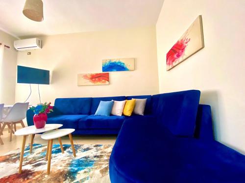 sala de estar con sofá azul y mesa en Ideal Home, en Shkodër