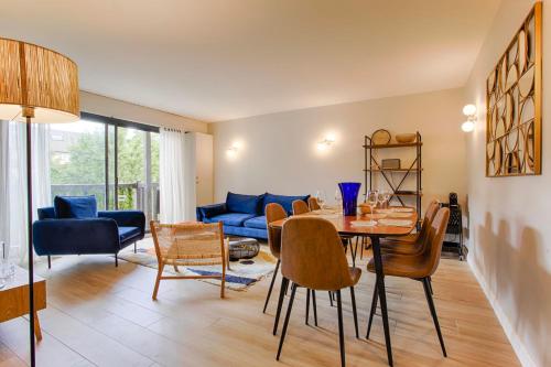 ein Wohnzimmer mit einem Tisch, Stühlen und einem Sofa in der Unterkunft Castel Saint Clair - Trois Pièces - Deauville Centre in Deauville