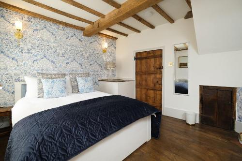 a bedroom with a bed and a blue and white wall at Joe's Cottage in Bridgnorth