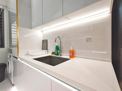 a kitchen with a sink in a white kitchen at Beacon Executive Suite at Georgetown for 10pax and 2 BED ROOM in George Town