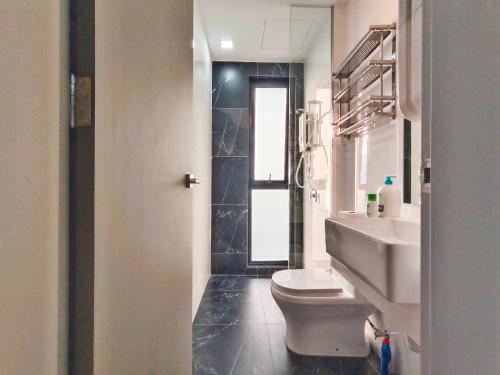 a bathroom with a white toilet and a sink at Beacon Executive Suite at Georgetown for 10pax and 2 BED ROOM in George Town