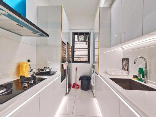 a white kitchen with a sink and a clock at Beacon Executive Suite at Georgetown for 10pax and 2 BED ROOM in George Town