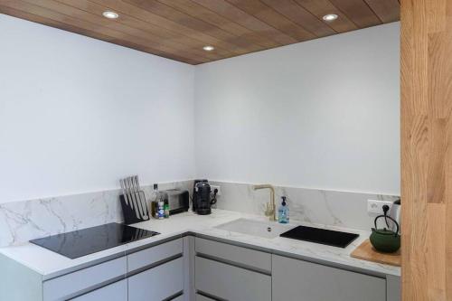 a white kitchen with a sink and a counter top at Villa Les Belles Vues de St Jean in Saint Barthelemy