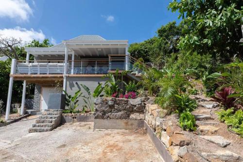a house on a hill with flowers and plants at Villa Les Belles Vues de St Jean in Saint Barthelemy
