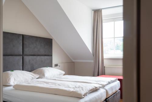 Un pat sau paturi într-o cameră la eee Hotel Perg