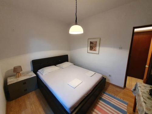 a small bedroom with a bed and a lamp at Petko in Herceg-Novi
