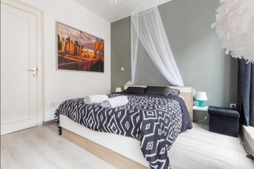 Un dormitorio con una cama con un edredón blanco y negro. en Apt B Boston, 25m2, Centre, Balcon, en Valenciennes