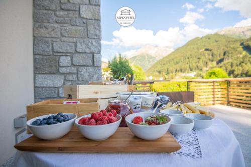a tray of bowls of fruit on a table at B&B Alpen Suite Ponte di Legno in Ponte di Legno