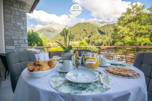 a table with food on it with mountains in the background at B&B Alpen Suite Ponte di Legno in Ponte di Legno