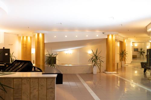 a lobby with a piano and a waiting room at Santa Marina Unique Hotel in Agios Nikolaos