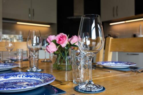 エディンバラにあるBlackfriars Residence - Beautiful Homeの木製テーブル(ワイングラス、皿、花付)
