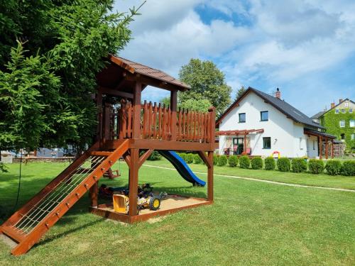 a playground with a slide in a yard at Dům a chatka pod Smrkem in Nové Město pod Smrkem