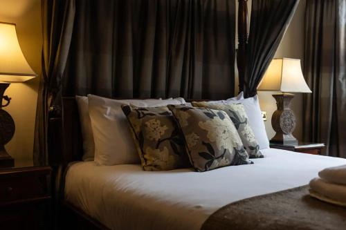 a bedroom with a bed with pillows and curtains at Blackfriars Residence - Beautiful Home in Edinburgh