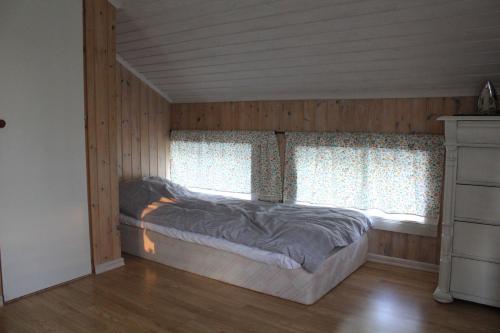 a bedroom with a bed and two windows at Lilly's house, Swedish High Coast in Docksta