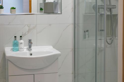 a white bathroom with a sink and a shower at Best Western Northfields Ealing Hotel in London