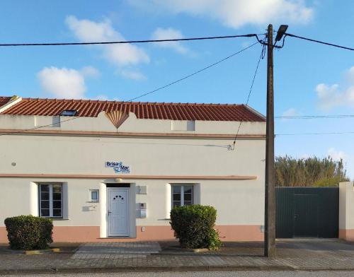 a white building with a blue door at Brisa Do Mar - Consolação in Peniche