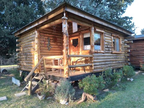 a log cabin with a porch in the yard at Pualy Resort & Spa in Belén de Escobar