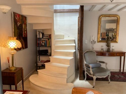 a staircase in a room with a chair and a mirror at La Berlue Bayeux in Saint-Vigor-le-Grand
