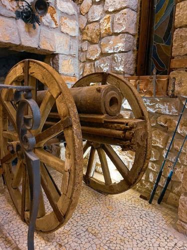a wooden cannon sitting in front of a stone wall at Solomon&Sons in Dhërmi