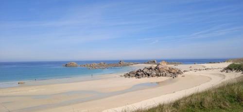 - une plage avec un tas de rochers et l'océan dans l'établissement maison de la plage des Amiets, à Cléder