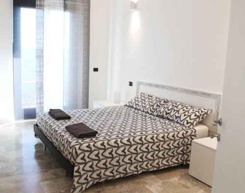 a white bedroom with a bed with black and white sheets at Bonaventura b&b and Bonaventura food in Tollo