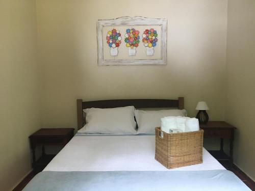 a bedroom with a bed with a basket of towels at Recanto da Floresta - Casa de campo em Secretário in Petrópolis