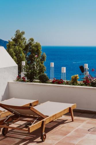 a bed and a table on a balcony with the ocean at Kalkan Han Hotel in Kalkan