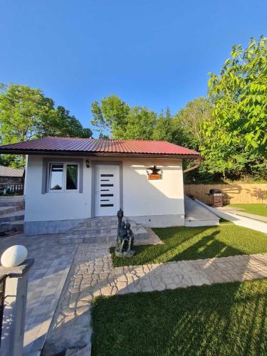 a small house with a dog sitting in front of it at Kuća za odmor "Arija" in Zlobin
