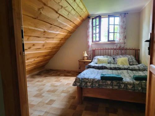 a bedroom with a bed and a wooden ceiling at Kaszubska Zagroda in Lipuska Huta